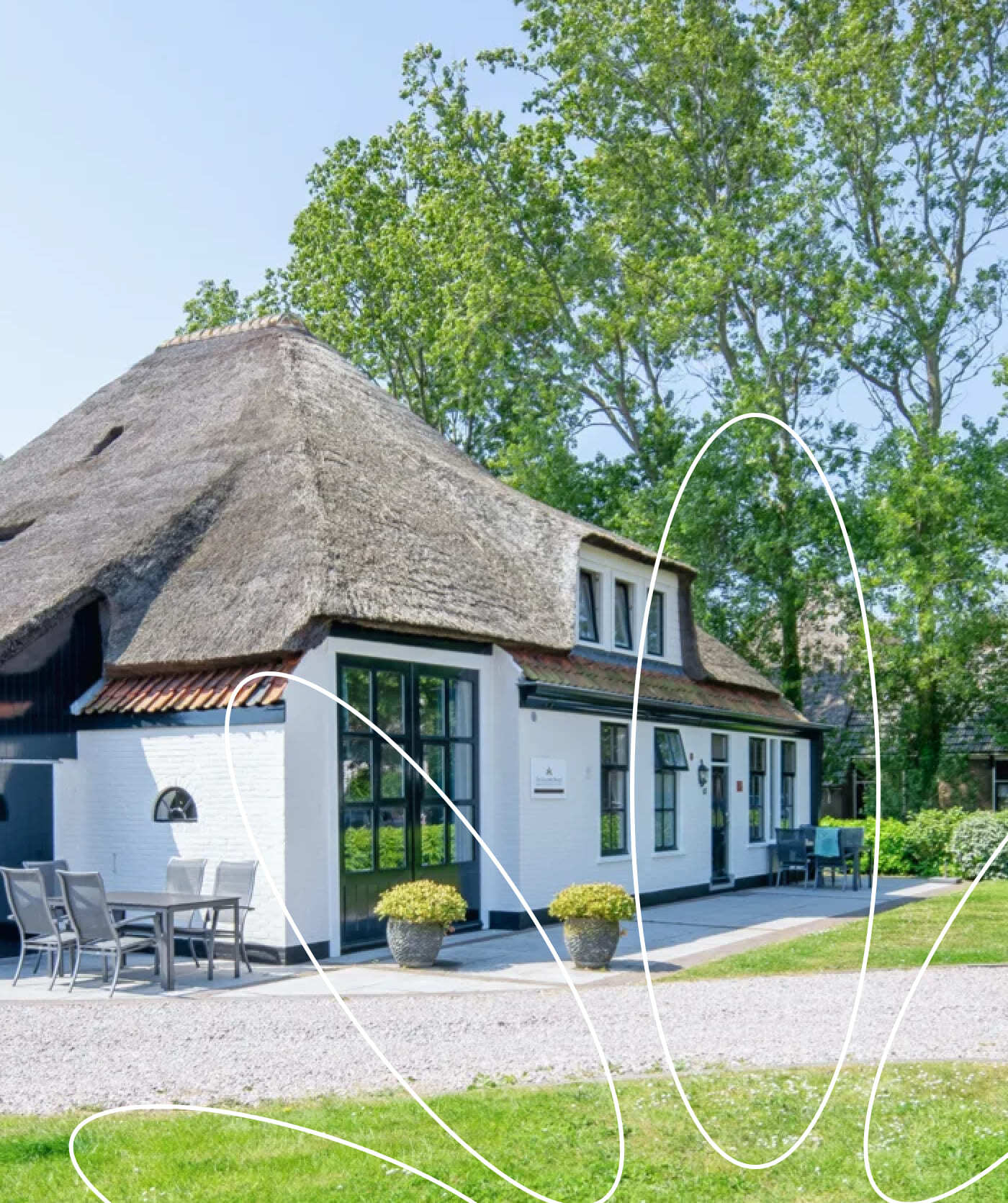 Een wit huis met een rieten dak en zwarte randen staat tussen groene bomen, met een terras en potplanten ervoor op een zonnige dag. Witte abstracte lijnen overlappen de afbeelding en roepen creativiteit op – perfecte inspiratie voor websites of webshops.